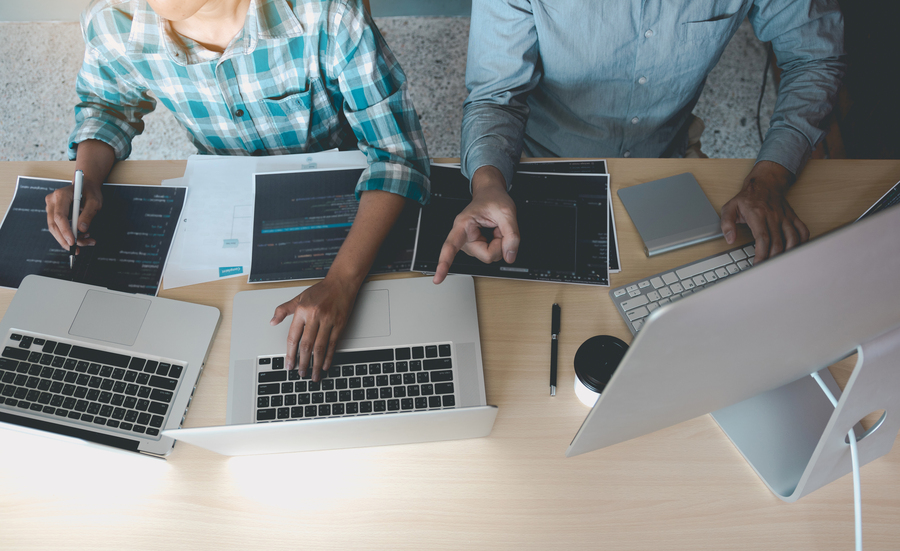 Developing programming and coding technologies working in a software engineers developing applications together in office.